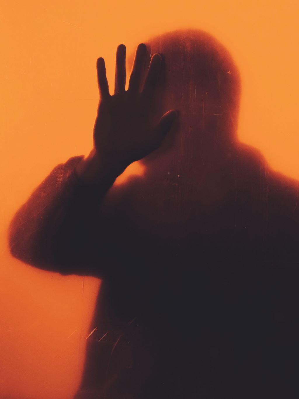 persons hand on orange background